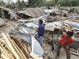 Algunos hombres revisan los restos de sus viviendas tras el paso de la fuerte tormenta en Gabtoli, Bangladesh. AP / S. Islam