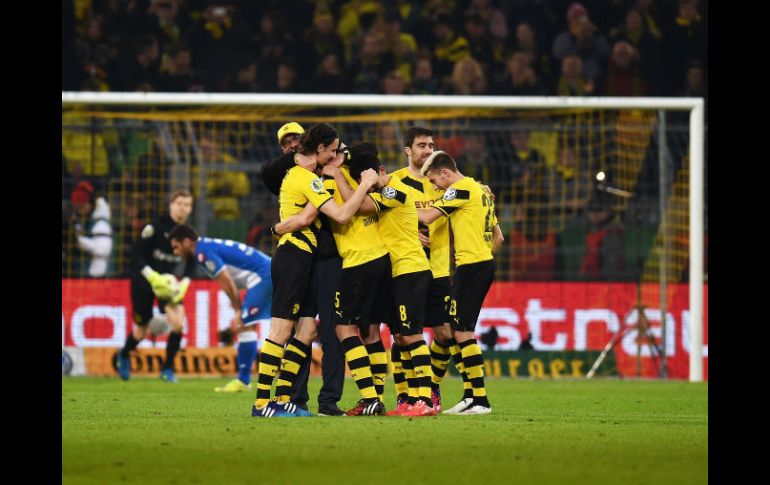 El técnico del Borussia Dortmund, Jürgen Klopp, se abraza con sus jugadores al consumarse la sufrida victoria sobre el Hoffenheim. AFP / P. Stollarz