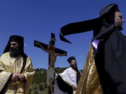 Al llegar a Grecia, el fuego se traslada en coche a la Iglesia del Santo Sepulcro de Plaka, donde se accede en procesión con cirios. EFE / O.Panagiotou