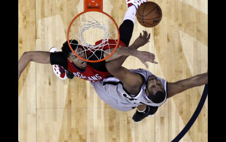 Anthony Davis (izq), de Nueva Orleans, y Boris Diaw, de San Antonio, disputan el balón bajo la canasta. AP / G. Herbert