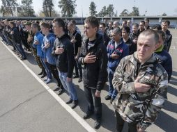 Nuevos reclutas ucranianos cantan el himno nacional antes de ser enviados al servicio militar en Kiev. EFE / s. Dolzhenko