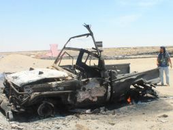 Un hombre permanece junto a los restos de un vehículo tras un ataque aéreo contra los rebeldes. AP / S. Al-Obeidi