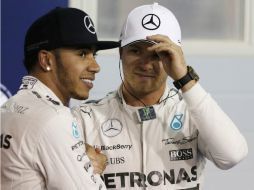 Lewis Hamilton saluda a Nico Rosberg, tercer lugar en la clasificación, tras lograr la ''pole'' en el Gran Premio de Barein. AP / L. Bruno