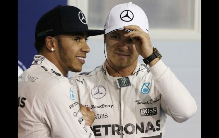 Lewis Hamilton saluda a Nico Rosberg, tercer lugar en la clasificación, tras lograr la ''pole'' en el Gran Premio de Barein. AP / L. Bruno