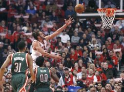 Joakim Noah dispara sobre la marca de O.J. Mayo y John Henson. AP / R. Arbogast