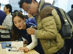 Clientes incondicionales a la marca observan el funcionamiento del nuevo Apple Watch. EFE / L. Wei