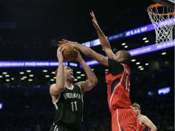 Brook Lopez (izq), de los Nets de Brooklyn dispara ante la defensa de Al Horford, de los Hawks de Atlanta. EFE / P. Foley