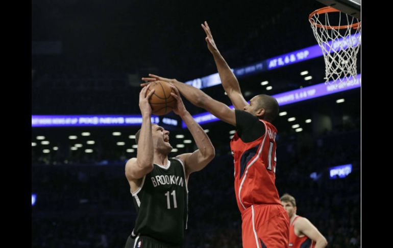 Brook Lopez (izq), de los Nets de Brooklyn dispara ante la defensa de Al Horford, de los Hawks de Atlanta. EFE / P. Foley