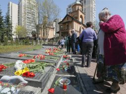 Cientos de personas depositaron flores y velas encendidas al pie del monumento de las víctimas. EFE / S. Dolzhenko