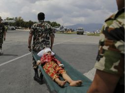 Un niño es auxiliado por militares indios que lo trasladan a un helicóptero de la Fuera Aérea. AP / A. Qadri