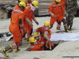 Un grupo de socorristas rescata a un menor sepultado entre escombros tras el sismo en Nepal. EFE /