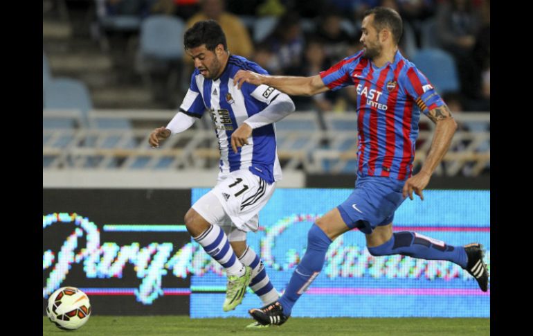 El mexicano (izq.) hizo estallar el recinto de San Sebastián con el soberbio cobro de tiro libre  en el  minuto 86. EFE / J. Herrero