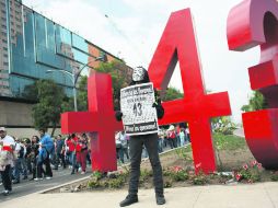 Un manifestante posa en el 'contramonumento' que colocaron activistas el 26 de abril en Paseo de la Reforma. AP /