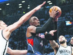 Paul Millsap (C), de los Hawks de Atlanta, previo a encestar ante la defensa de Brook Lopez (D) de los Nets. EFE /