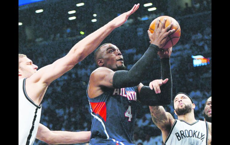 Paul Millsap (C), de los Hawks de Atlanta, previo a encestar ante la defensa de Brook Lopez (D) de los Nets. EFE /