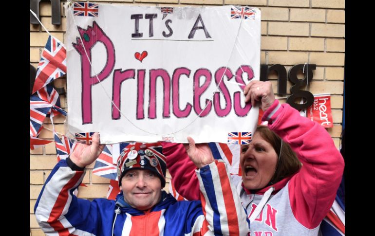 Fanáticos de la realeza celebran el nacimiento de la nueva princesa de Cambridge afuera del hospital St. Mary. AFP / L. Neal