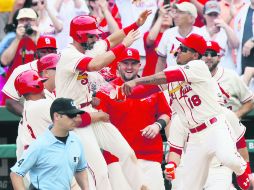 Matt Carpenter (Izq) es recibido en el plato tras sentenciar el triunfo de los Cardenales. AP / C. Lee