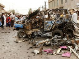 Personas se quedan mirando el vehículo destruido por una bomba del Estado Islámico. EFE / ARCHIVO