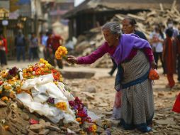 Una mujer deposita flores en memoria de las víctimas mortales del terremoto del 25 de abril en Nepal. EFE / Shreshta