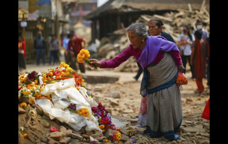 Una mujer deposita flores en memoria de las víctimas mortales del terremoto del 25 de abril en Nepal. EFE / Shreshta