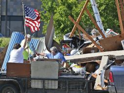 Ciudadanos de Oklahoma recogen sus pertenencias al tiempo de izan la bandera de Estados Unidos. AP / S. Ogrocki