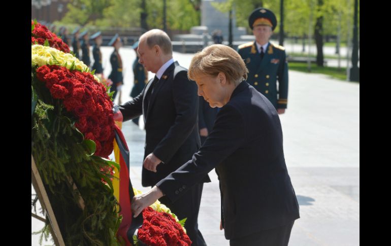 Merkel depositó una ofrenda floral en la tumba del Soldado Desconocido junto al Kremlin, acompañada por Putin. EFE / Host Photo Agency