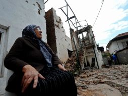 Una mujer descansa fuera de su casa, dañada durante el segundo combate entre fuerzas policiales y el grupo armado del UCK en Skopje. AFP / R. Atanasovski