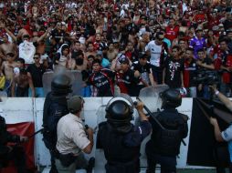 Integrantes de la 'Barra 51' invadieron la cancha del Estadio Jalisco y se enfrentaron con la policía. EL INFORMADOR / R. Tamayo