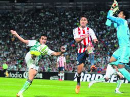 El mediocampista Diego González de Santos dispara ante la salida del portero de las Chivas, Luis Ernesto Michel. MEXSPORT /