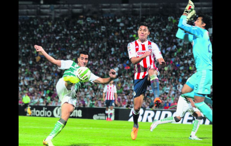 El mediocampista Diego González de Santos dispara ante la salida del portero de las Chivas, Luis Ernesto Michel. MEXSPORT /