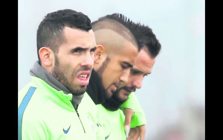 Carlos Tevez (izq.) y el chileno Arturo Vidal (centro), titulares habituales de la Juve, arrancarían como suplentes ante el Napoli. AFP / M. Bertorello