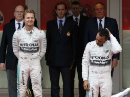 Nico Rosberg (izquierda), flanquea con una ligera sonrisa al Lewis Hamilton, que se toma el cabello aún molesto con el resultado. AP / L. Bruno