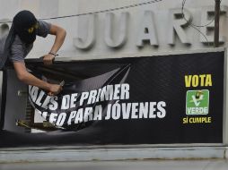 Enmascarados se deshacen de la propaganda de los partidos políticos al término de la marcha. AFP / O. Torres