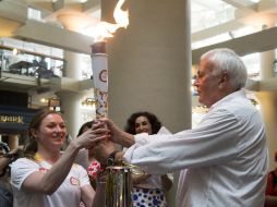 La atleta Rosie MacLennan recibe la antorcha de los Juegos Panamericanos Toronto 2015 del presidente David Petterson. AP / F. Gunn