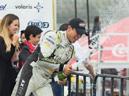 Irwin Vences, quien de paso saltó de la segunda a la primera posición en el campeonato, celebra su triunfo en el podio. TWITTER / @MRacingMex