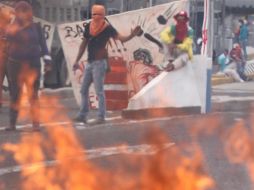 Un grupo de maestros saca una manta de más de 10 metros cuadrados y le prenden fuego. NTX /