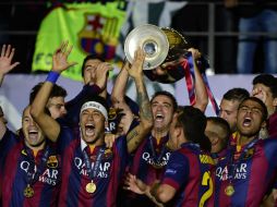 La plantilla del Barcelona festeja la consecución de su quinta orejona; cuatro de ellas obtenidas en los últimos nueve años. AFP / O. Morin