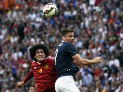 Marouane Fellaini disputa el balón con Olivier Giroud. El mediocampista del ManU hizo dos de los goles belgas. AFP / L. Venance