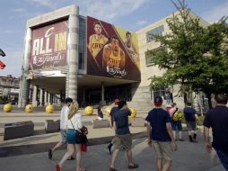 Personas caminan a las afueras del Quicken Loans Arena, que esta noche será escenario del tercer juego entre Cavaliers y Warrios AP / T. Dejak