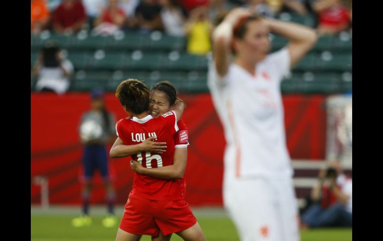 Wang Lisi abraza a su compañera de quipo Lou Jiahui (#16) después de anotar el tanto del triunfo ante Holanda. AFP / T. Korol