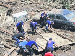 Ruinas. Voluntarios limpian los escombros en la capital georgiana. AFP /