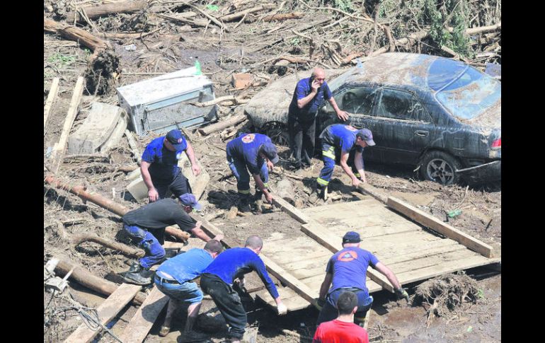 Ruinas. Voluntarios limpian los escombros en la capital georgiana. AFP /