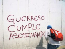 Un joven hace una pinta contra el Gobierno estatal por la desaparición de los 43 normalistas. AP / ARCHIVO