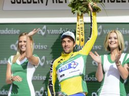 El ciclista francés Thibaut Pinot (centro), del equipo FDJ, viste el jersey amarillo de líder mientras celebra su victoria. EFE / J. Bott