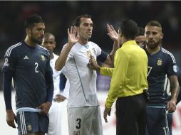 Diego Godín gesticula frente al árbitro Sandro Meira durante el partido contra Argentina. AFP / J. Mabromata