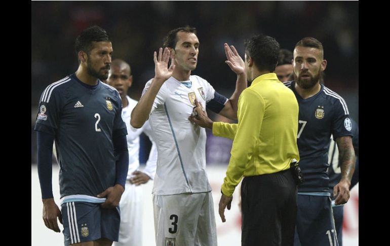 Diego Godín gesticula frente al árbitro Sandro Meira durante el partido contra Argentina. AFP / J. Mabromata