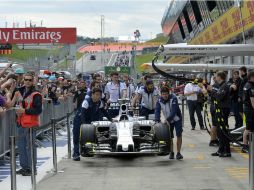 Miembros del equipo Mercedes llevan uno de los monoplazas de la escudería que serán utilizados en el Gran Premio de Austria. EFE / H. Neubauer