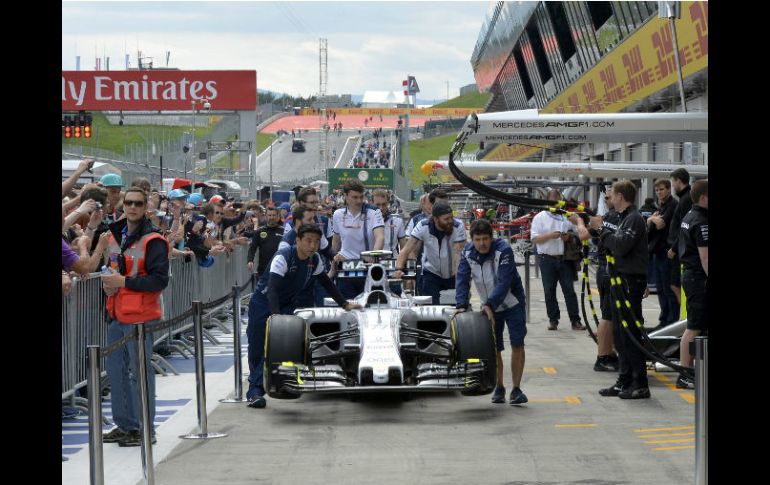 Miembros del equipo Mercedes llevan uno de los monoplazas de la escudería que serán utilizados en el Gran Premio de Austria. EFE / H. Neubauer