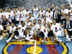 Los jugadores del Real Madrid  celebran su triunfo y posan con el trofeo de la Liga Endesa. EFE / A. Dalmau