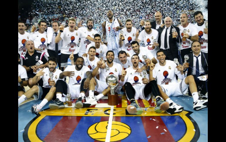 Los jugadores del Real Madrid  celebran su triunfo y posan con el trofeo de la Liga Endesa. EFE / A. Dalmau